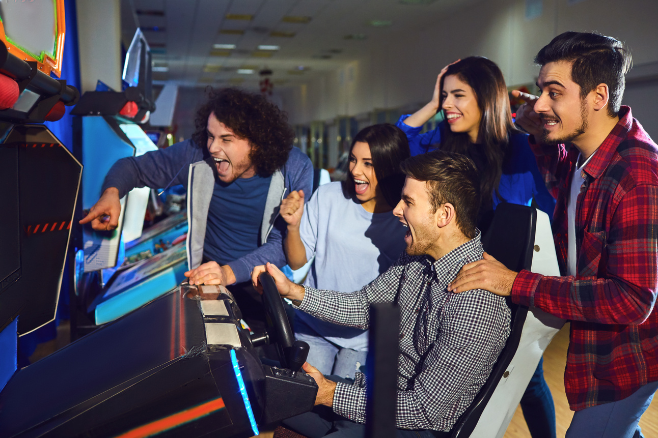 A Group of Friends Playing Arcade Machine